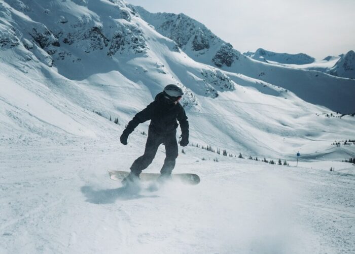 Photo by Benjamin Hayward a man riding a snowboard down a snow covered slope